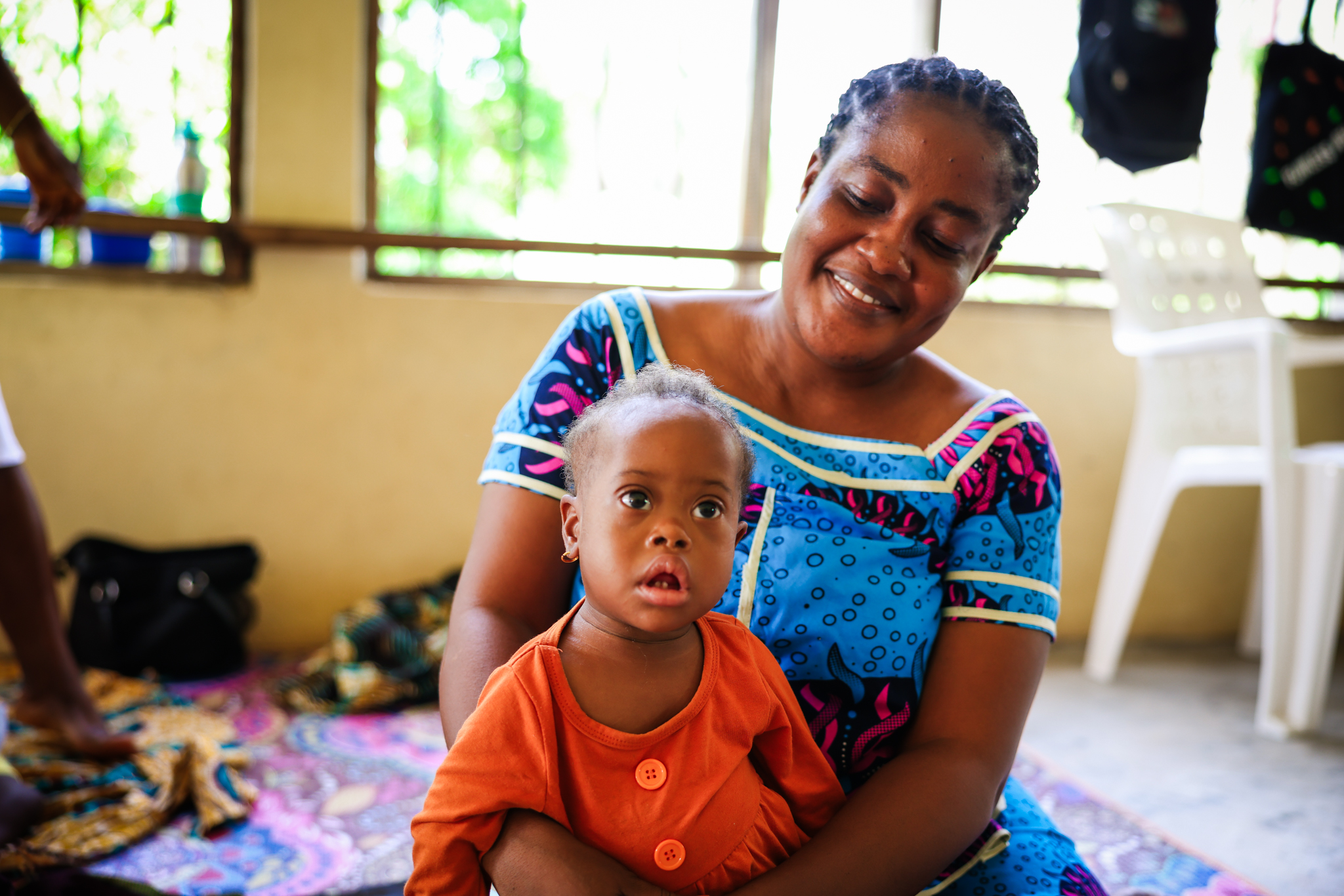 A smiling mother holds her little boy at the Jesus Loves Me Children's Center in Liberia