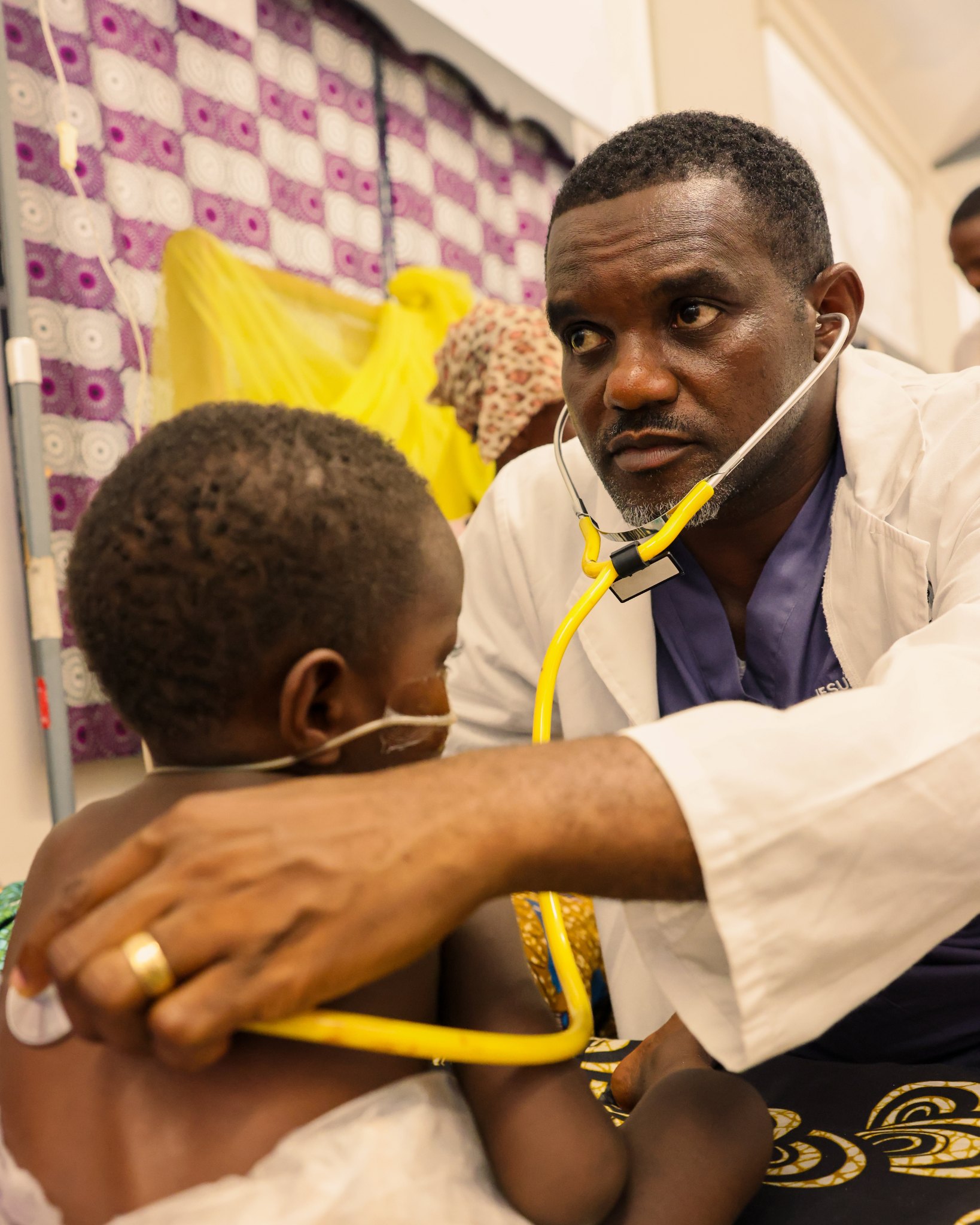 A Children’s Center doctor listens to a young patient with a stethoscope.