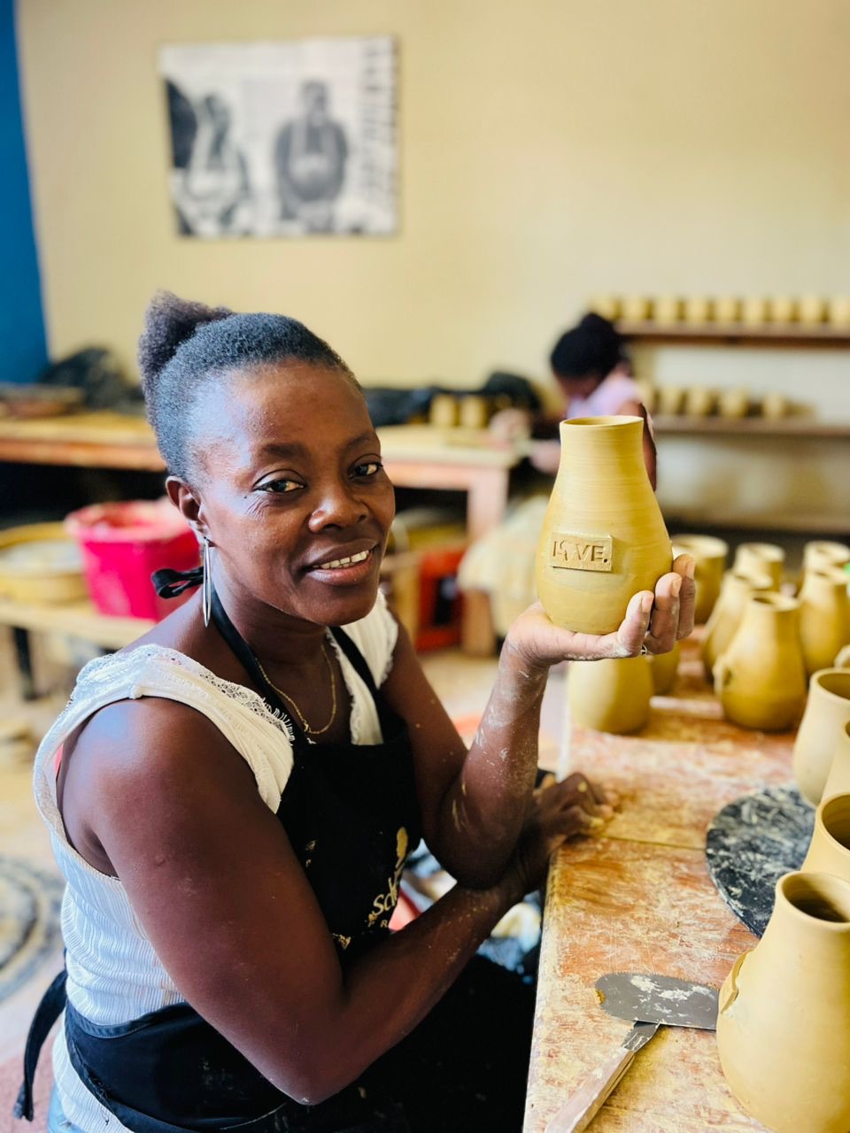 A potter in Haiti shapes a handmade LOVE. vase.