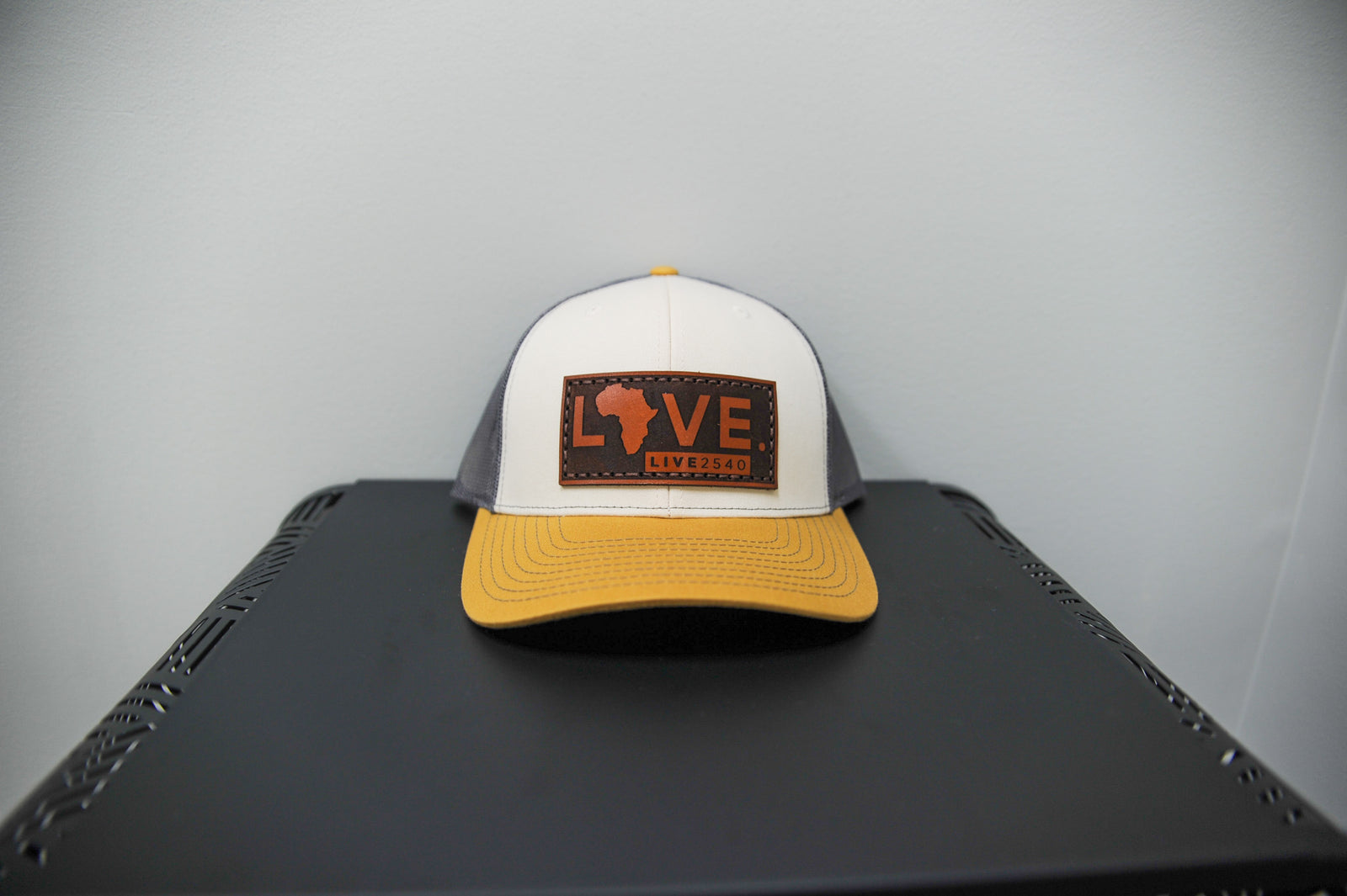 A beige LOVE. leather patch hat.