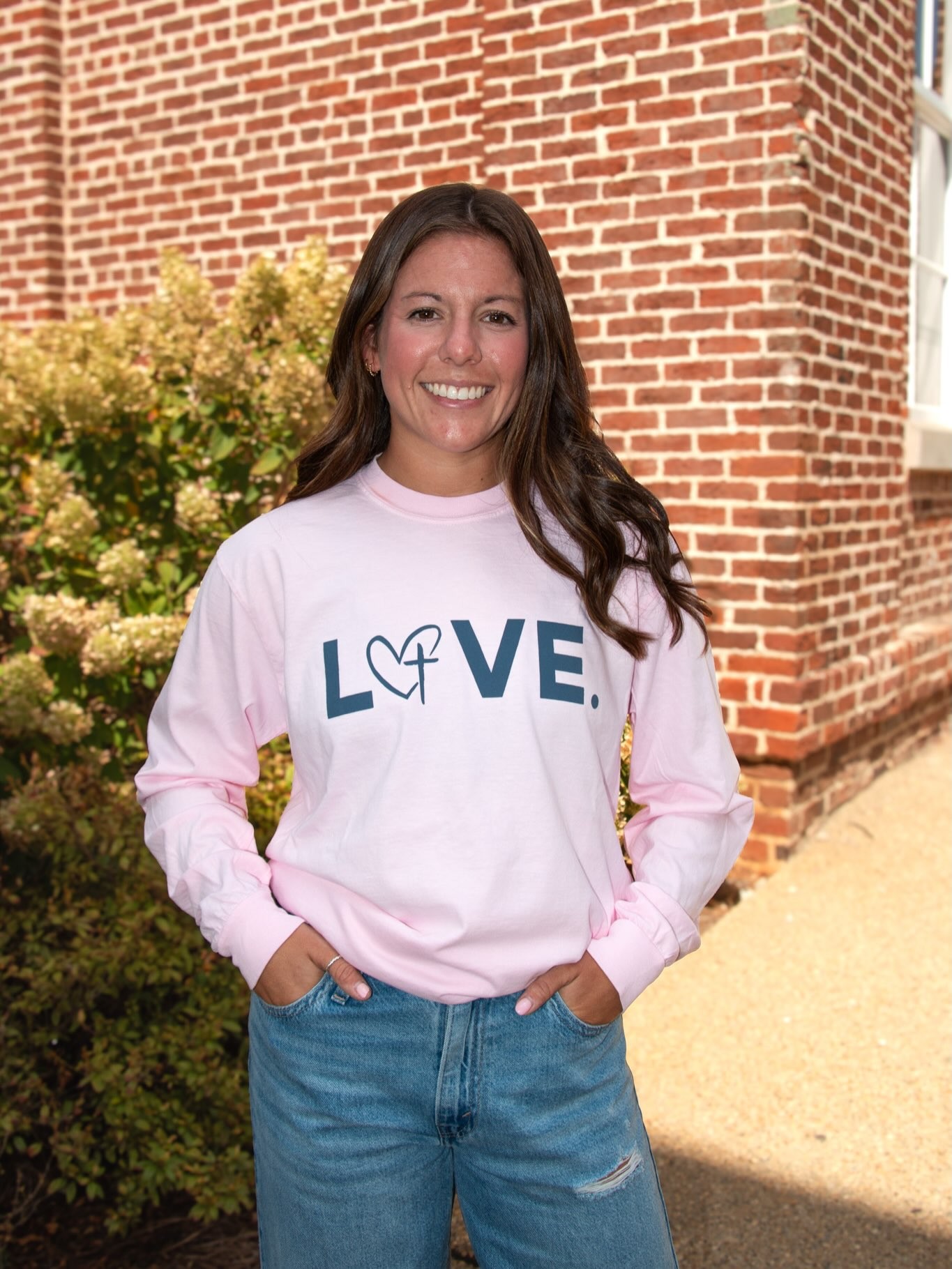 A woman in a pink LOVE. sweatshirt.